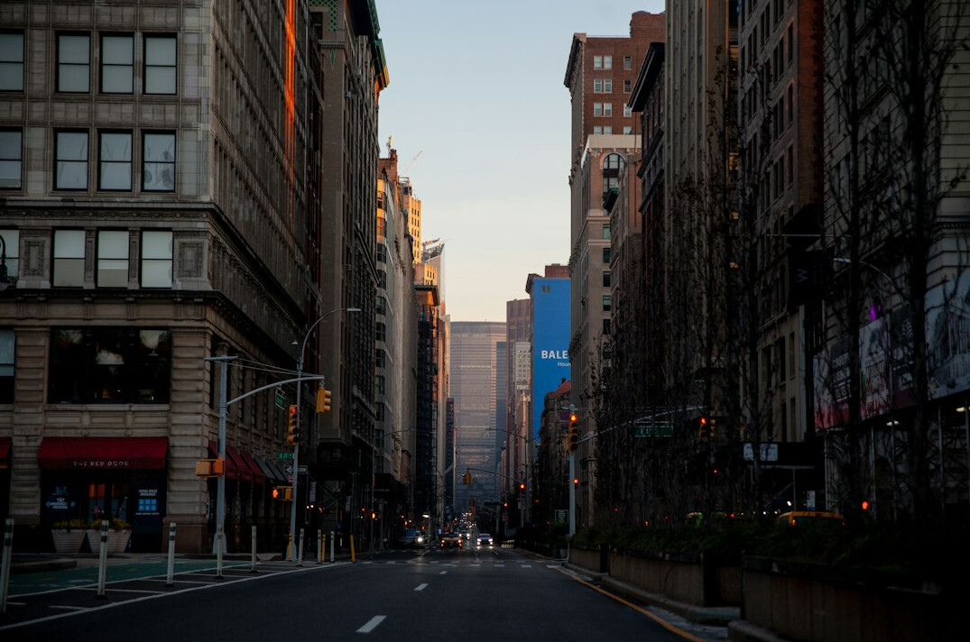 Quiet city street with morning light and pedestrians