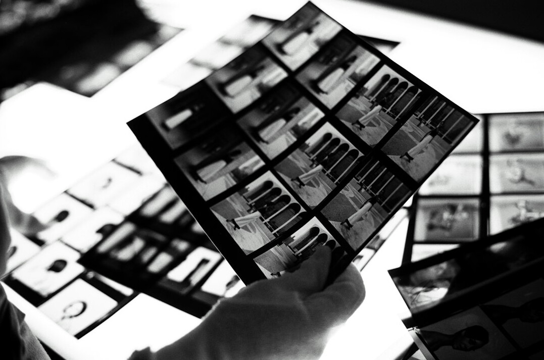 Hands reviewing printed photographs on a table