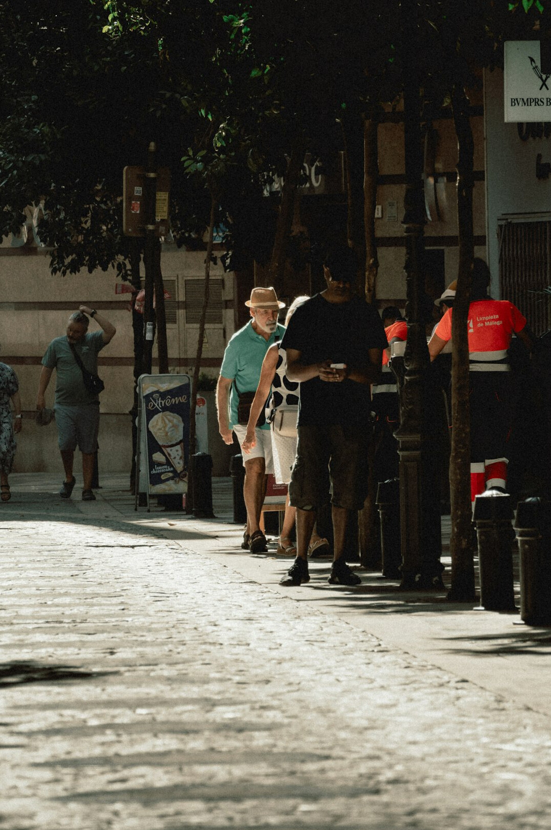 People standing in a queue outside on a city sidewalk